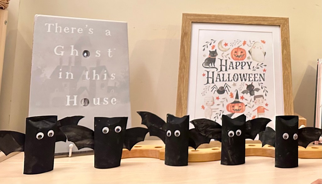 Handmade Halloween bats made from painted cardboard tubes with paper wings and googly eyes