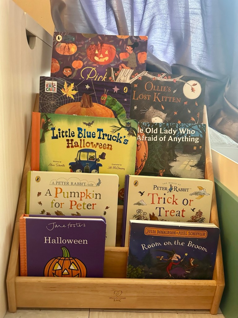 Our collection of Halloween picture books for children displayed in a wooden book basket