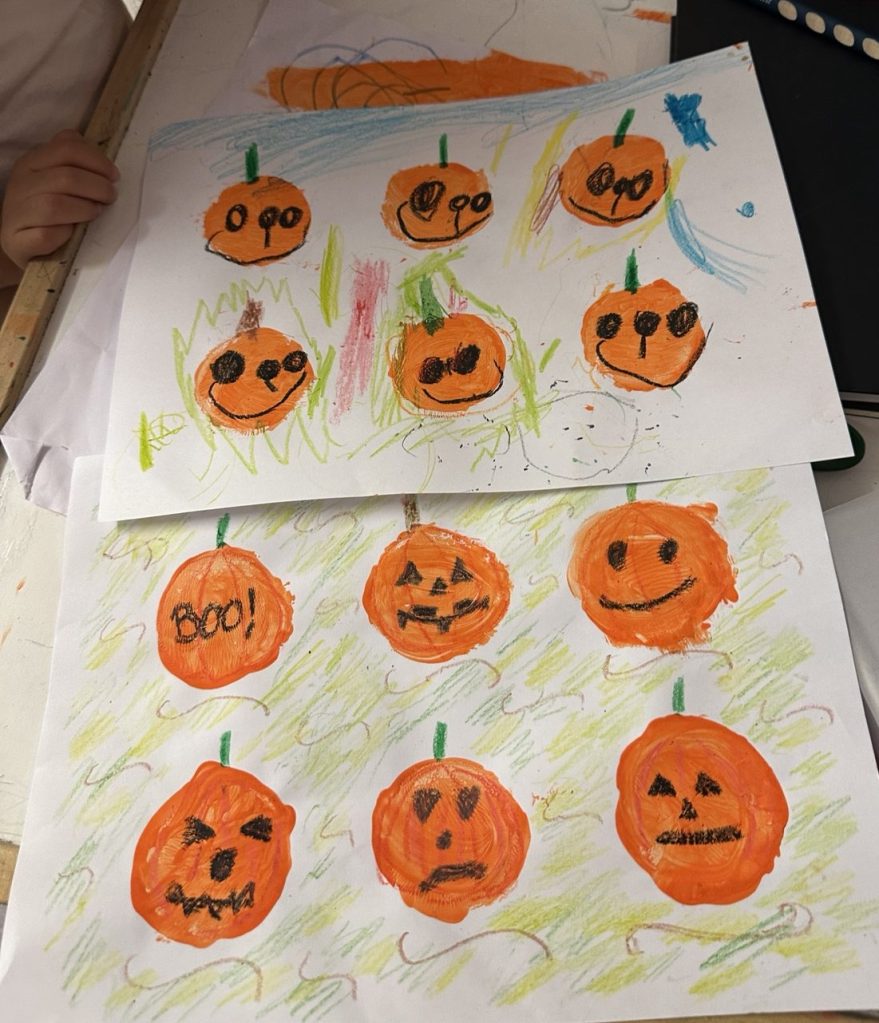 Child creating colourful Halloween pumpkin artwork